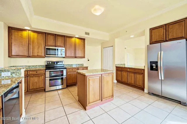 a kitchen with stainless steel appliances granite countertop a refrigerator and a stove top oven