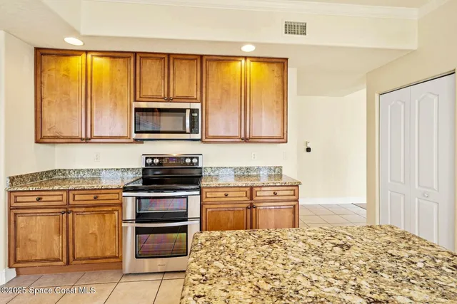 a kitchen with stainless steel appliances granite countertop a stove top oven microwave and cabinets