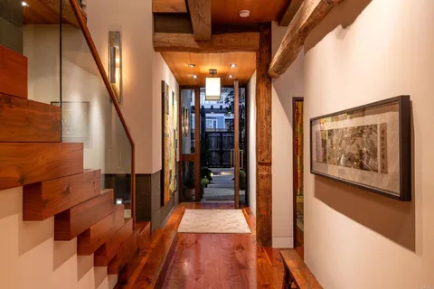 a view of a hallway with wooden floor and staircase