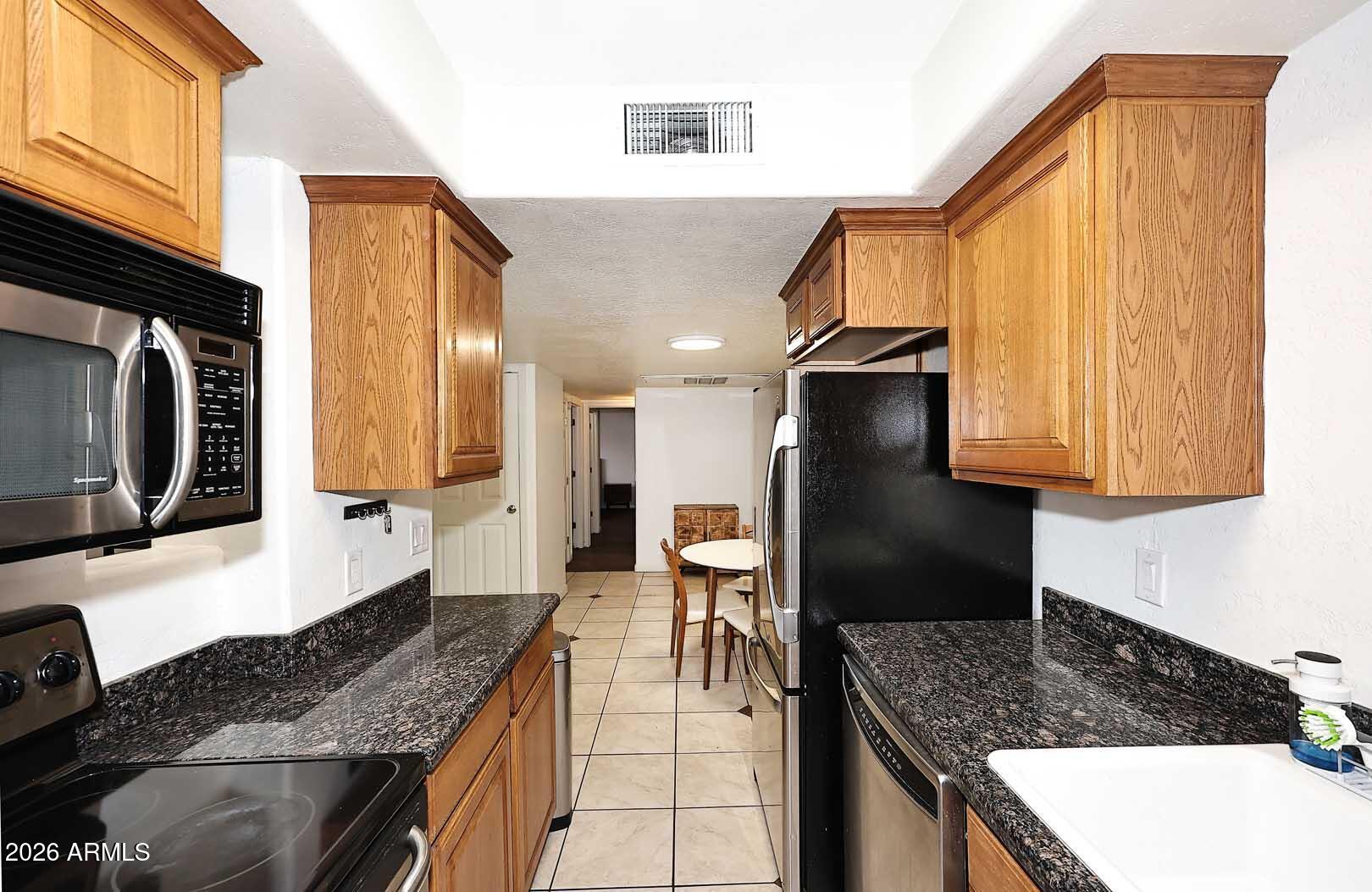 151 East Broadway Road, Unit 103 Tempe, AZ 85282 - Photo 3 of 37 Kitchen to Dining & Bedroom Hallway