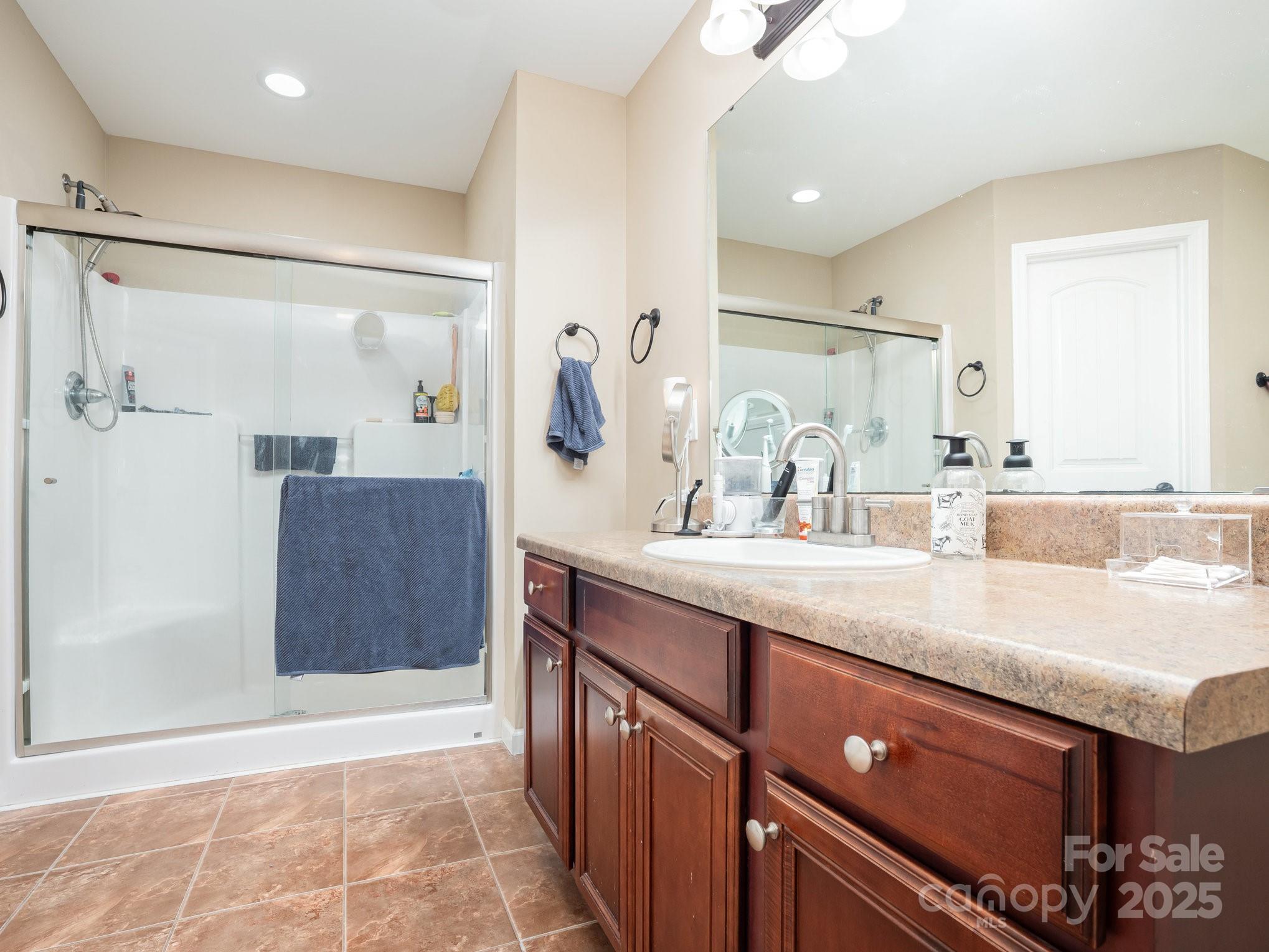 190 Glendower Lane Chesnee, SC 29323 - Photo 21 of 29 a bathroom with a granite countertop sink a mirror and a shower