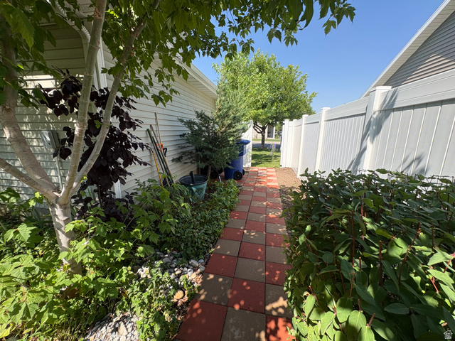 922 North 480 West Logan, UT 84321 - Photo 2 of 11 Tiled pathway composed of red and gray pavers, bordered by established landscaping