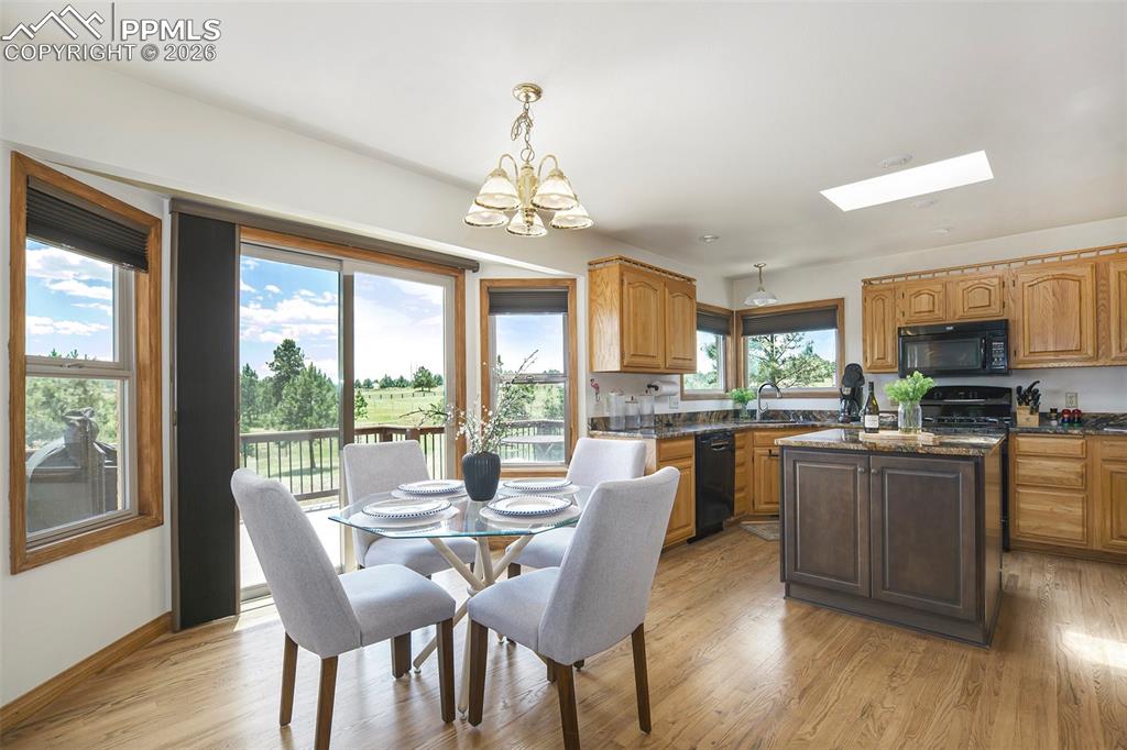 2585 Mohawk Way Monument, CO 80132 - Photo 15 of 49 a view of a dining room with furniture large windows and wooden floor