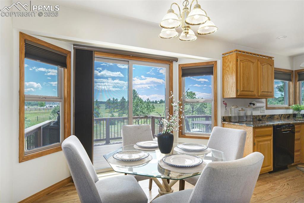 2585 Mohawk Way Monument, CO 80132 - Photo 16 of 49 a view of a dining room with furniture large windows wooden floor and a chandelier