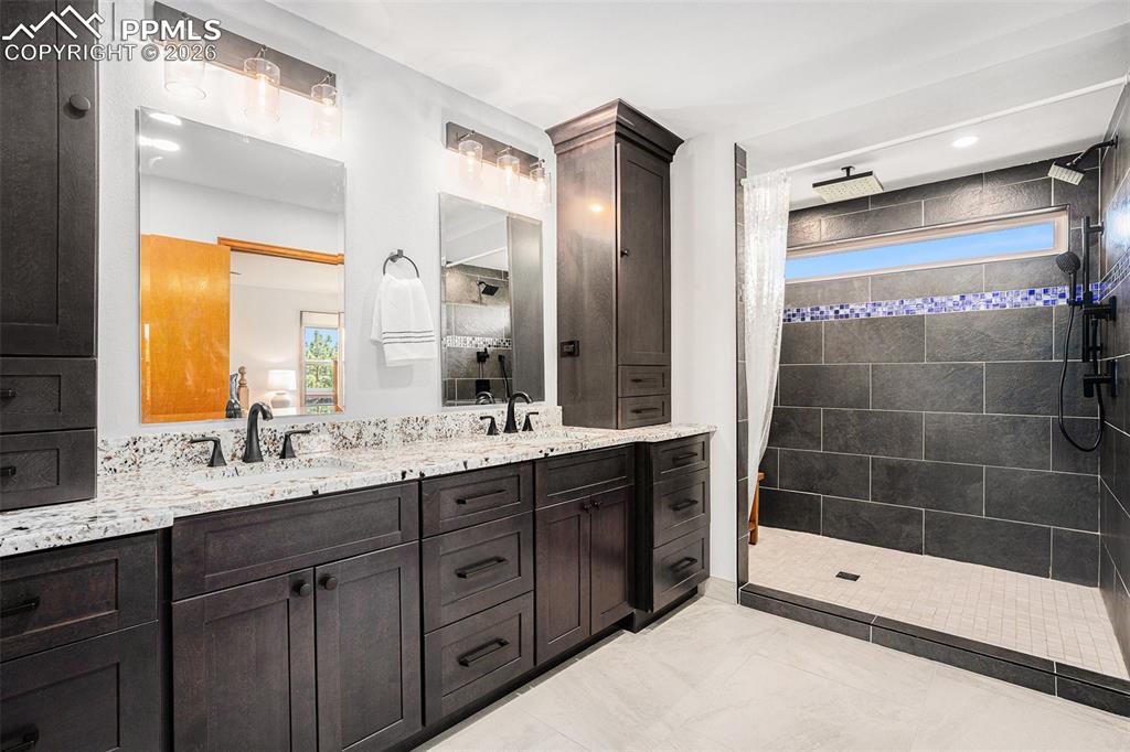 2585 Mohawk Way Monument, CO 80132 - Photo 22 of 49 a bathroom with a shower sink and mirror