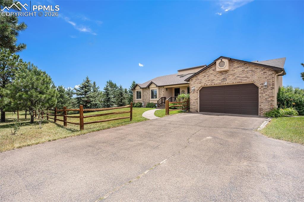 2585 Mohawk Way Monument, CO 80132 - Photo 46 of 49 a front view of a house with a yard and garage