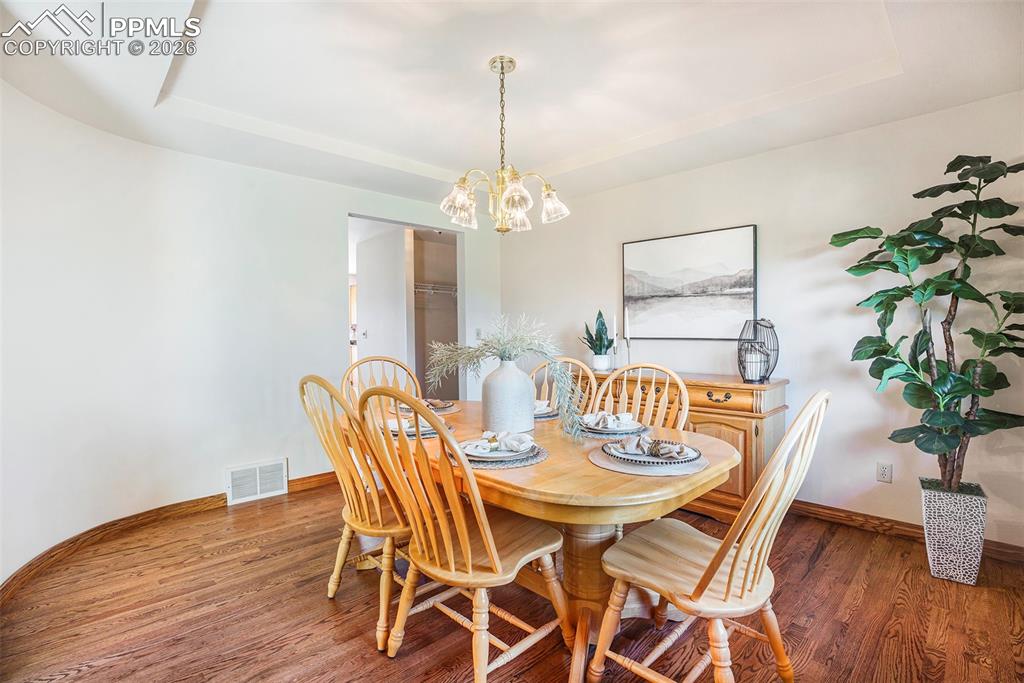 2585 Mohawk Way Monument, CO 80132 - Photo 10 of 49 a dining room with furniture potted plants and wooden floor
