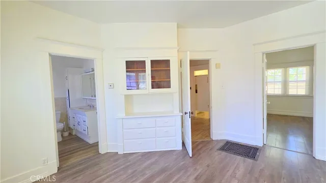 wooden floor in an empty room with a bathroom