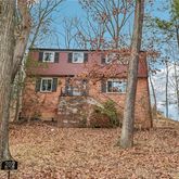 a view of a brick house next to a large tree