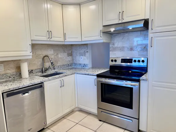 a kitchen with granite countertop cabinets stainless steel appliances and a sink
