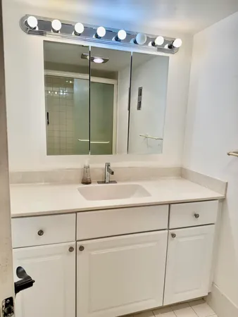 a bathroom with a sink vanity and mirror
