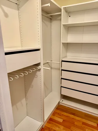 a view of walk in closet with empty racks