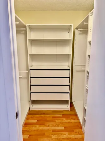 a view of walk in closet with empty racks