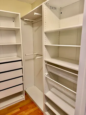 a view of walk in closet with empty racks