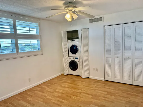 an empty room with closet and windows