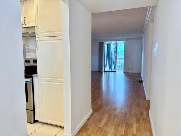 a view of a hallway with wooden floor and closet