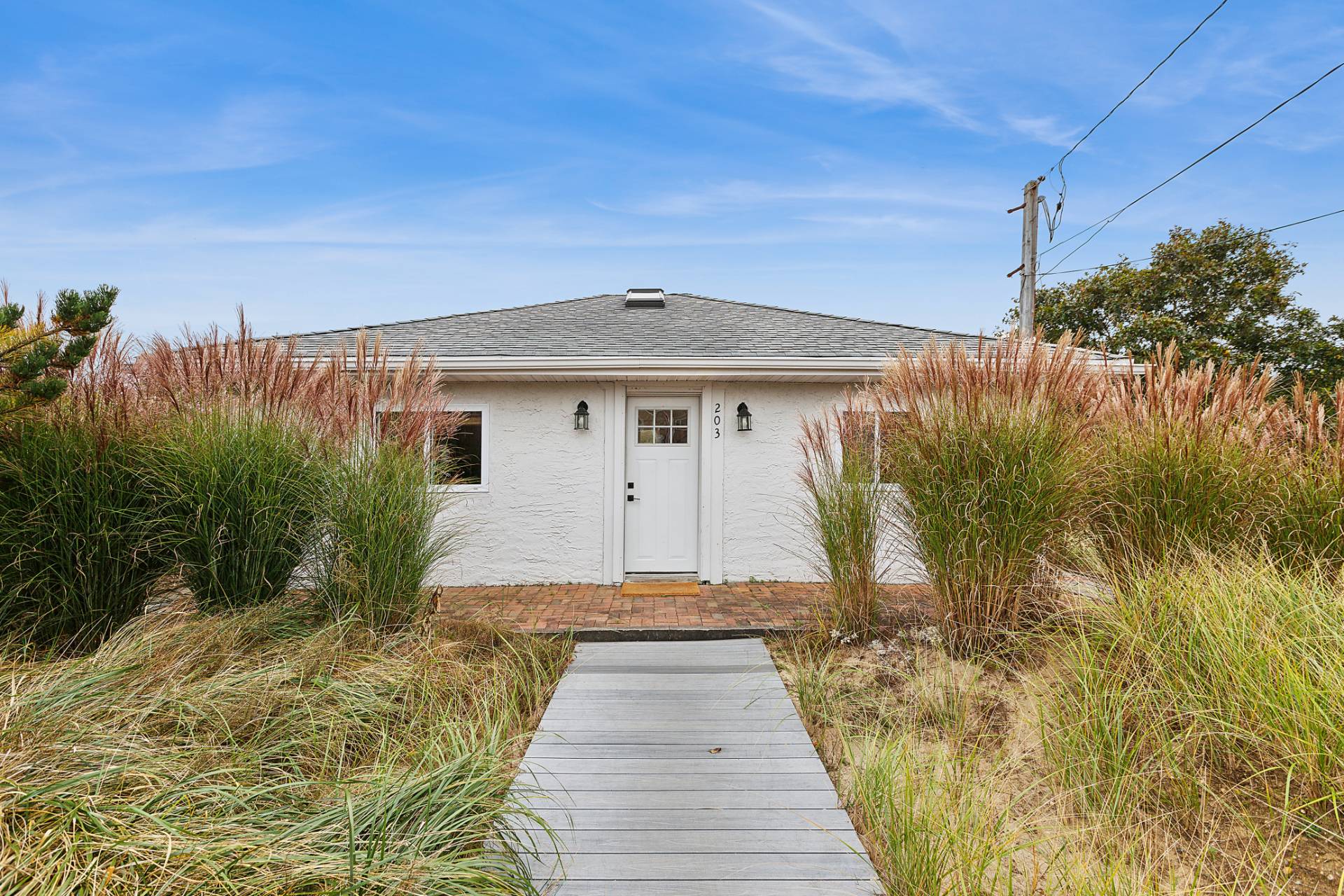 203 Shore Road Amagansett, NY 11930 - Photo 16 of 20 a front view of a house with a yard