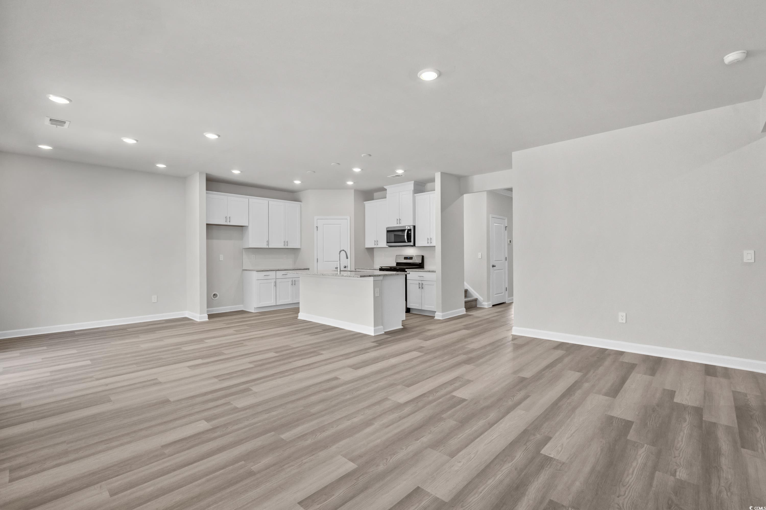 2052 Copper Crk Loop Longs, SC 29568 - Photo 10 of 40 Unfurnished living room with light wood-style floo