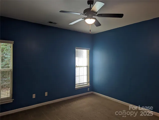 an empty room with closet and a chandelier fan