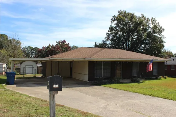 a front view of a house with yard and trees