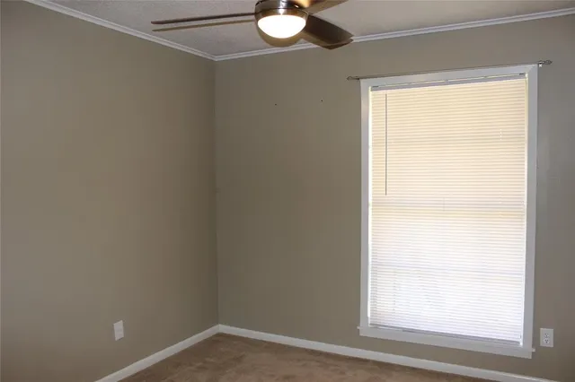 a view of a room with a ceiling fan and a window
