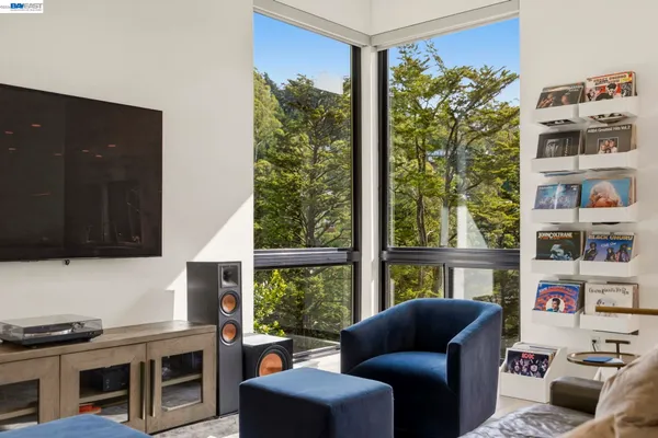 a living room with furniture kitchen view and a large window