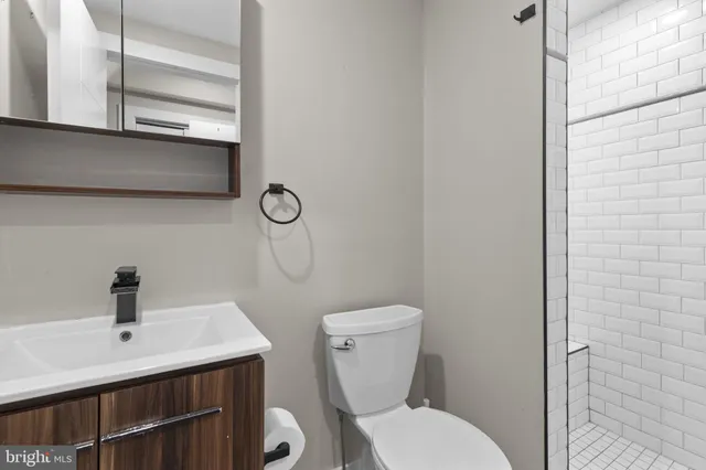 a bathroom with a toilet a sink and mirror