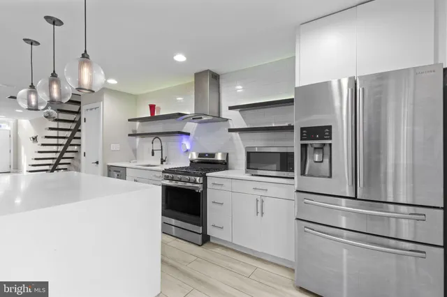 a kitchen with kitchen island a sink stainless steel appliances and cabinets