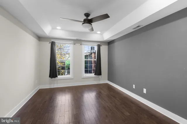 an empty room with wooden floor and windows