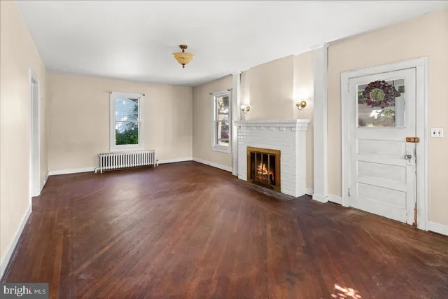 an empty room with windows and fireplace
