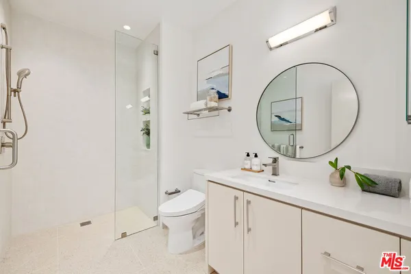 a bathroom with a sink a toilet and a mirror