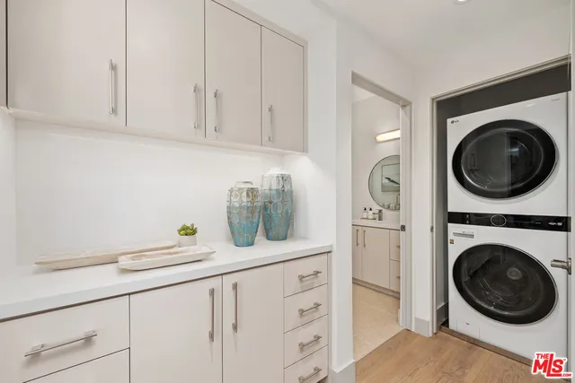a kitchen with white cabinets and washer