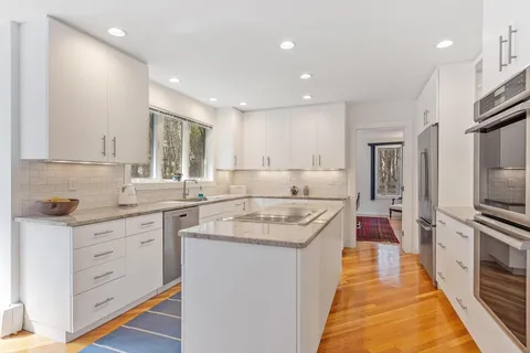 a kitchen with white cabinets sink and stainless steel appliances