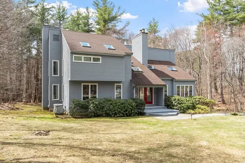 a front view of house with yard and trees around