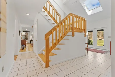 a view of an entryway with wooden floor and a front door