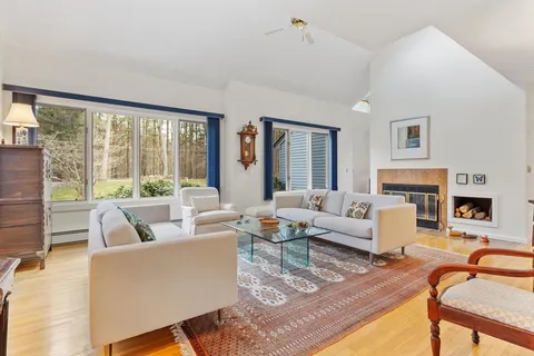 a living room with fireplace furniture and a large window