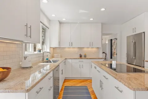 a kitchen with a sink a counter top space cabinets and stainless steel appliances