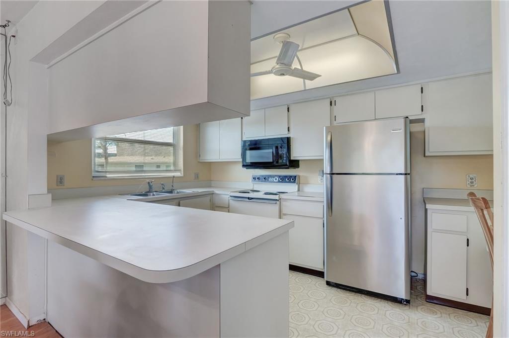 115 Georgetown Boulevard, Unit 115 Naples, FL 34112 - Photo 11 of 45 a kitchen with appliances a sink and a refrigerator