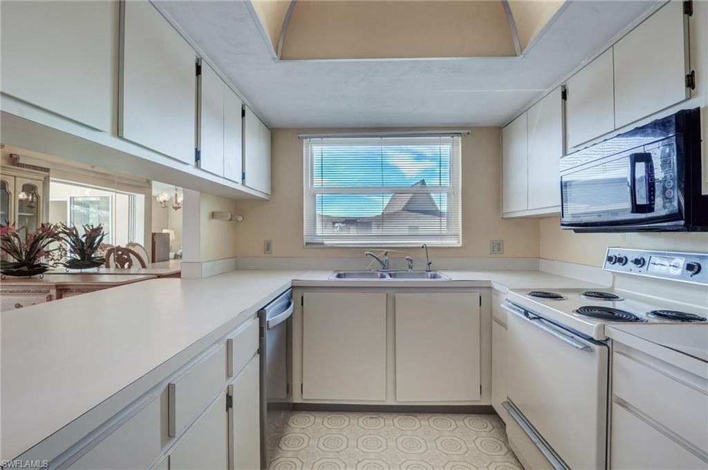 115 Georgetown Boulevard, Unit 115 Naples, FL 34112 - Photo 12 of 45 a kitchen with a sink stove and cabinets