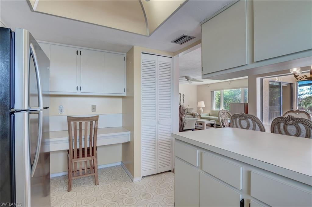 115 Georgetown Boulevard, Unit 115 Naples, FL 34112 - Photo 13 of 45 a kitchen with a sink chairs and cabinets