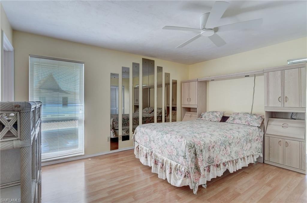 115 Georgetown Boulevard, Unit 115 Naples, FL 34112 - Photo 14 of 45 a bedroom with a large bed and a chandelier