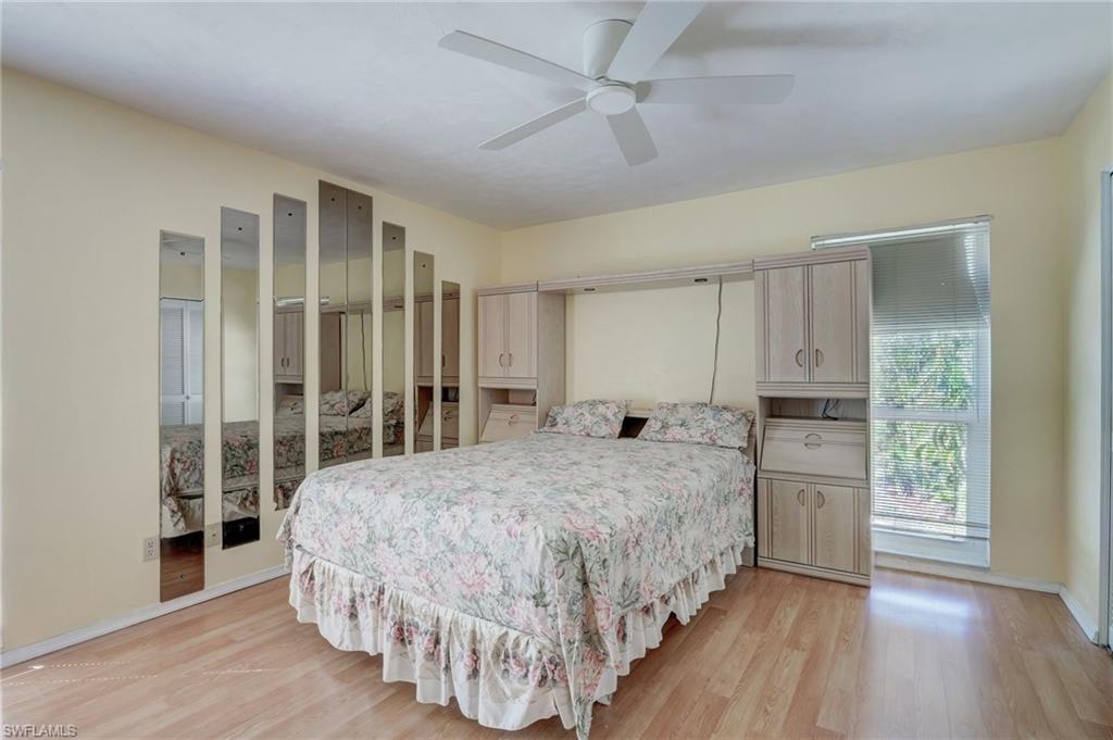 115 Georgetown Boulevard, Unit 115 Naples, FL 34112 - Photo 15 of 45 a bedroom with a large bed and wooden floor