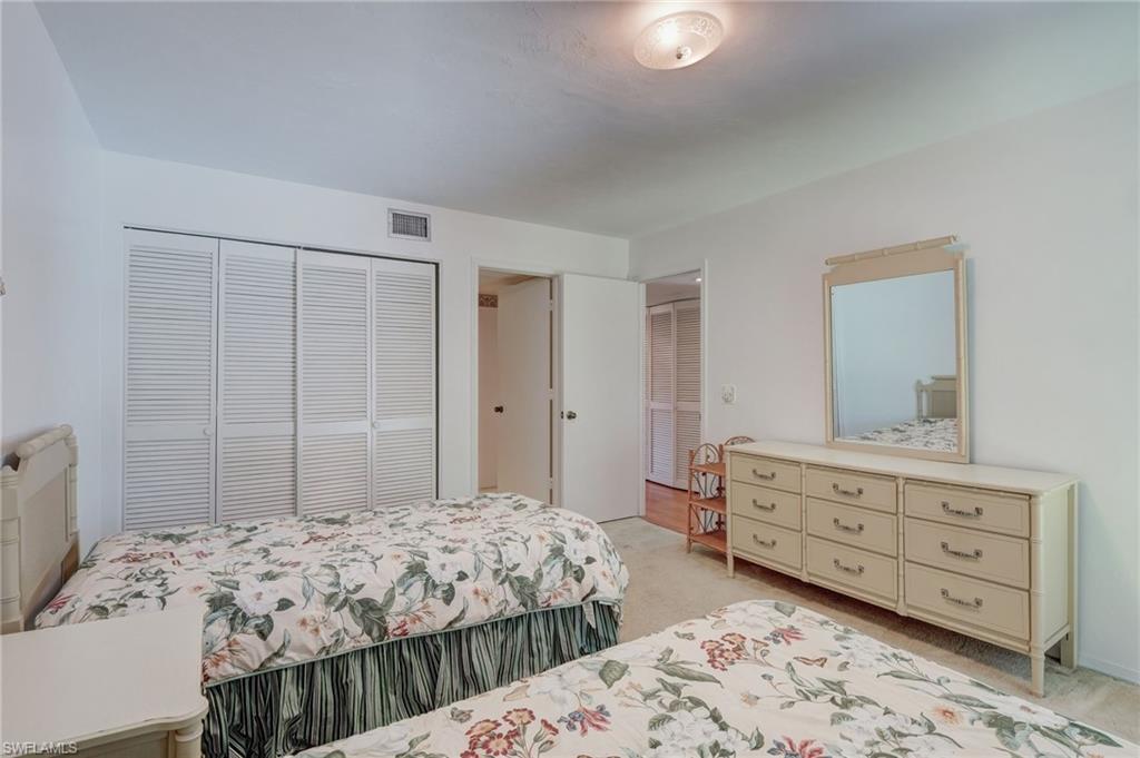 115 Georgetown Boulevard, Unit 115 Naples, FL 34112 - Photo 19 of 45 a bedroom with a bed and a dresser
