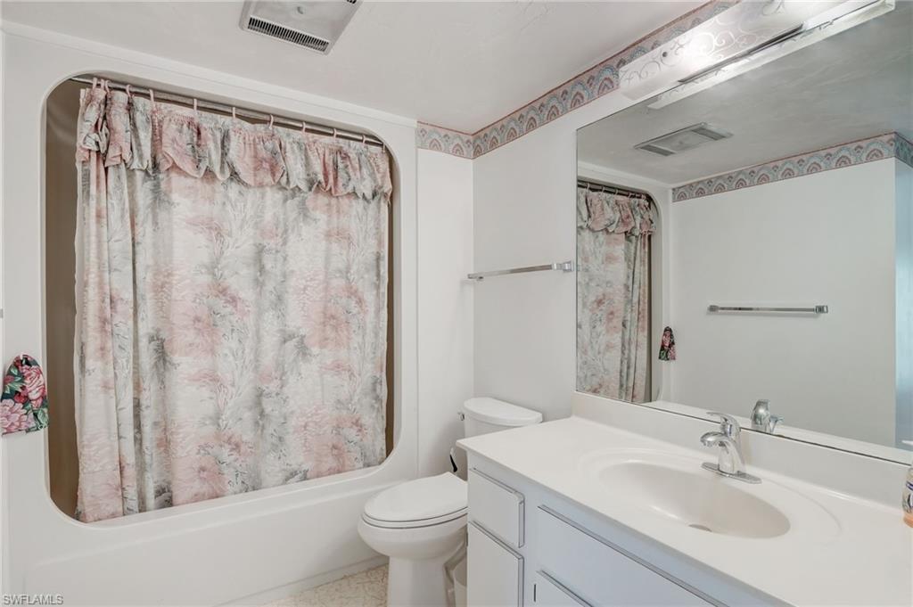 115 Georgetown Boulevard, Unit 115 Naples, FL 34112 - Photo 20 of 45 a bathroom with a sink a toilet and shower curtain