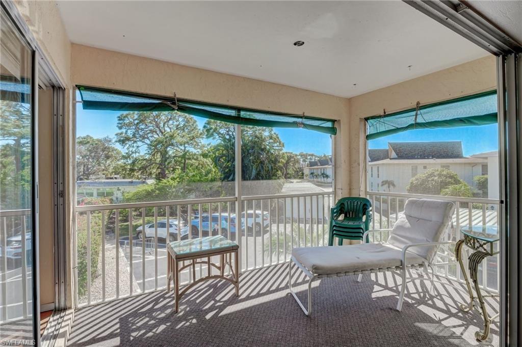 115 Georgetown Boulevard, Unit 115 Naples, FL 34112 - Photo 22 of 45 a view of a porch with furniture and wooden floor