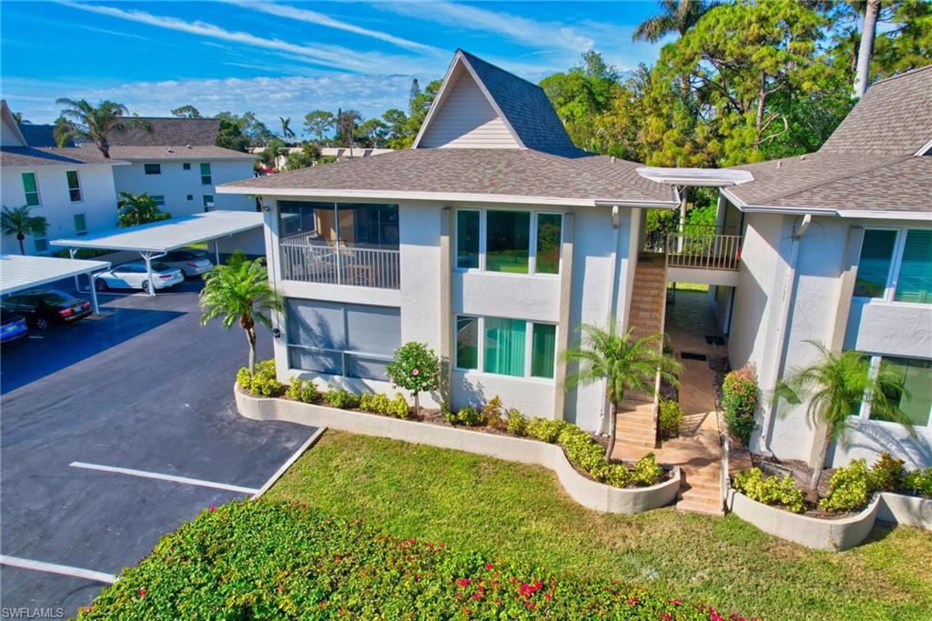 115 Georgetown Boulevard, Unit 115 Naples, FL 34112 - Photo 28 of 45 a front view of a house with a yard and potted plants