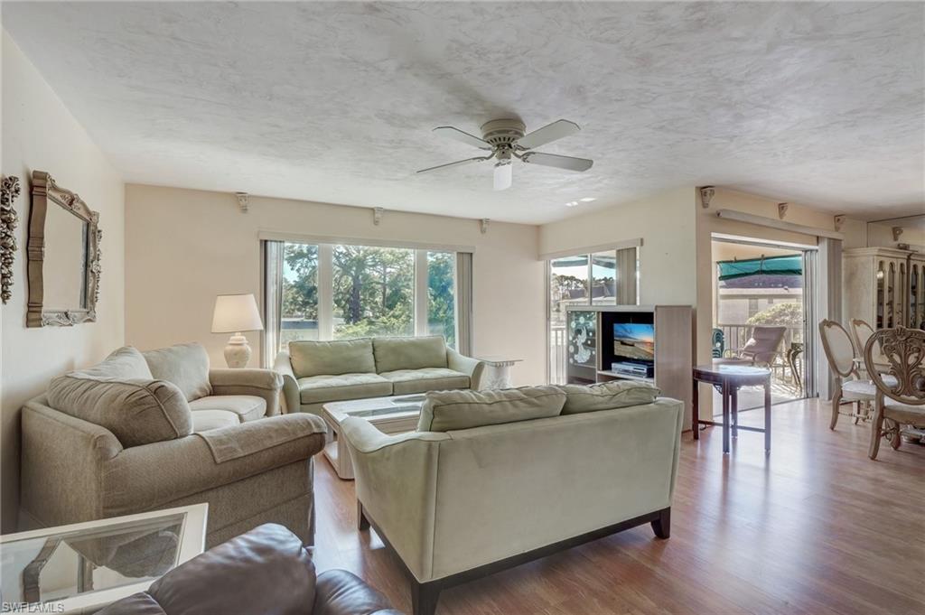 115 Georgetown Boulevard, Unit 115 Naples, FL 34112 - Photo 3 of 45 a living room with furniture and a large window