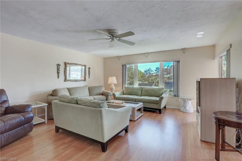 115 Georgetown Boulevard, Unit 115 Naples, FL 34112 - Photo 5 of 45 a living room with furniture and a large window