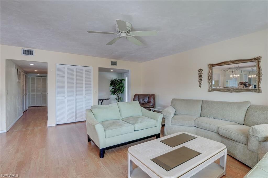 115 Georgetown Boulevard, Unit 115 Naples, FL 34112 - Photo 7 of 45 a living room with furniture and a wooden floor