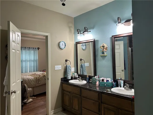 a en suite bathroom with a double vanity sink and a mirror